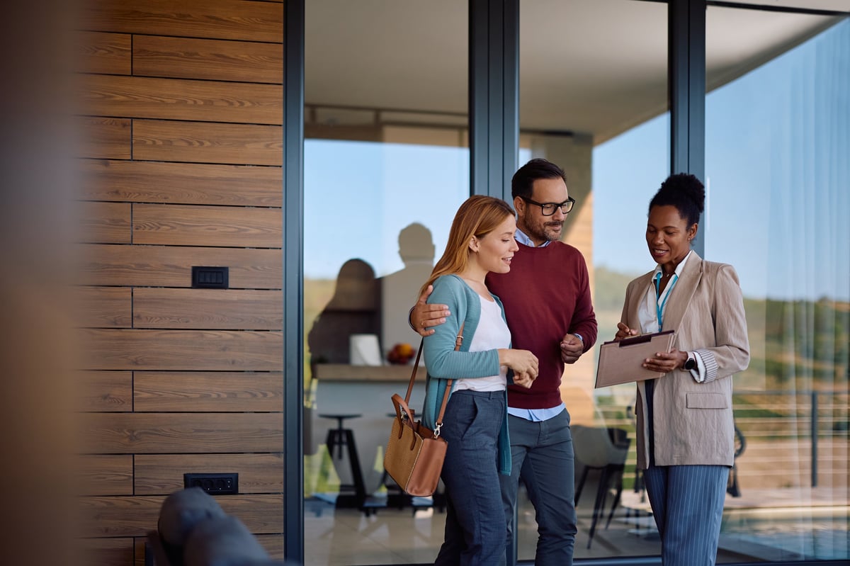 African American real estate agent going through housing plans with a couple who is buying a new home